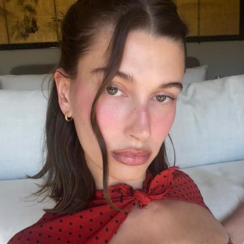 Η Χέιλι Μπίμπερ με κόκκινο πουά φόρεμα και ροζ ρουζ