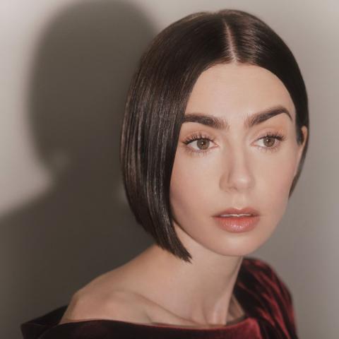 η λίλι κολλινς με μπορντό φόρεμα και καρέ μαλλιά