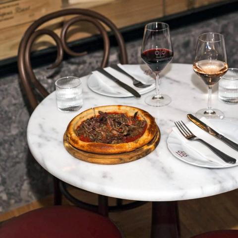 Πίτσα και ποτήρια στο τραπέζι