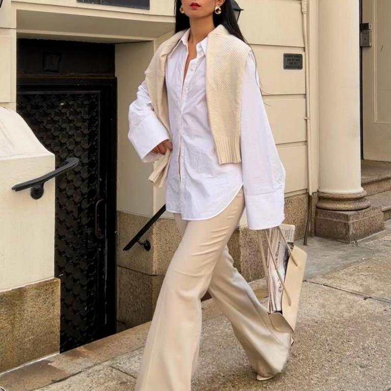 στιλάτη γυναίκα με λευκό πουκάμισο κρατά τσάντα
